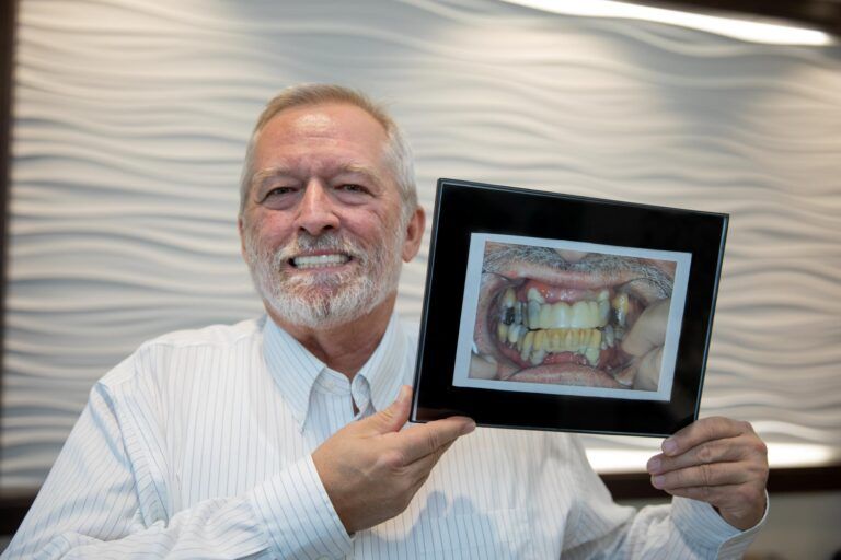 man smiling holding photo